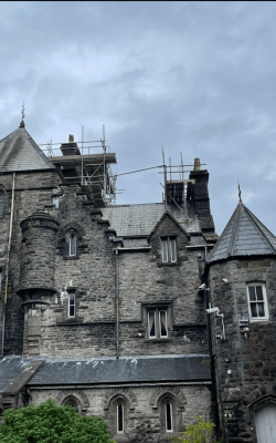 Large old building with scaffolding on roof