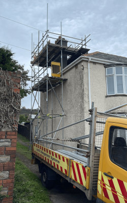 Side of home with scaffolding, access to the chimney