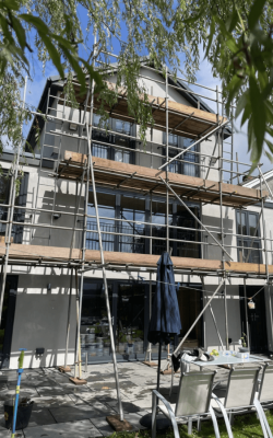 Three story modern home covered in scaffolding