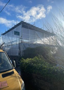 Large building protected by scaffolding and plastic