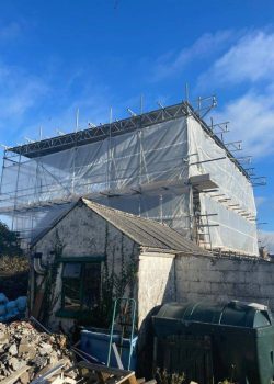 Large building protected by scaffolding and plastic