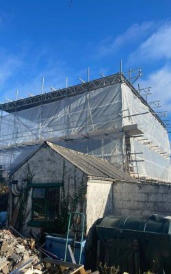 Large building protected by scaffolding and plastic